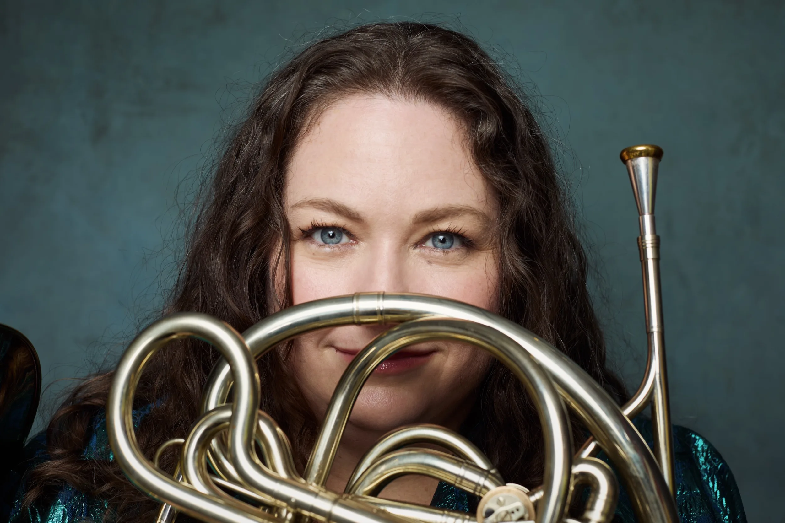 Megan Cullen, horn player, photographed behind the bell of her instrument